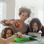 woman helping 3 children pack their lunches