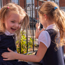 Two young primary school girls laughing together in the playground.