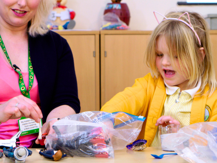 Child Playing With Toys With An Adult In A Clinic