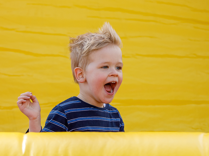 Young boy shouting, having fun at an inflatable playground
