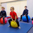 4 Young Children Sitting On Space Hoppers In A Classroom Vibrant